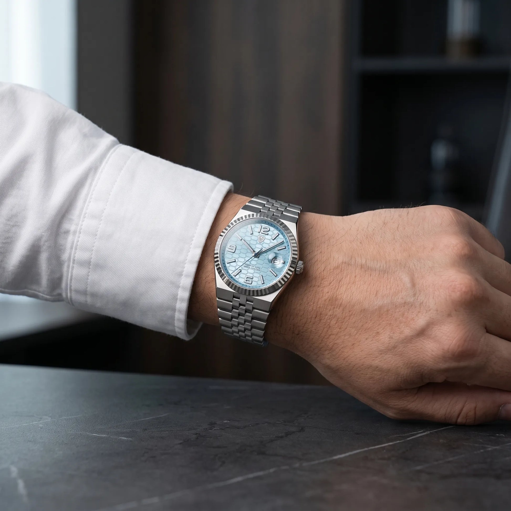 Montre homme luxe acier bracelet jubilé portée au poignet avec chemise blanche
